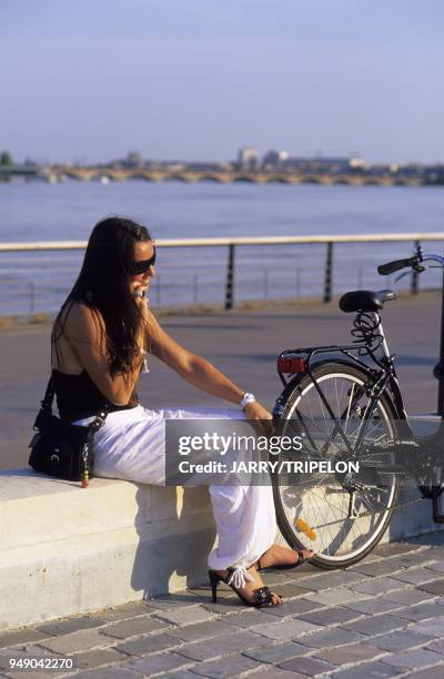 Femme telephonant avec son portable sur les quais de la Garonne, Bordeaux, departement de la Gironde, region Aquitaine, France woman phoning, quay of...