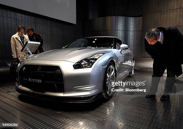 Customers look at a Nissan Motor Co. "GT-R" sports vehicle displayed at the automaker's gallery in Tokyo, Japan, on Friday, Jan. 25, 2008. Honda...