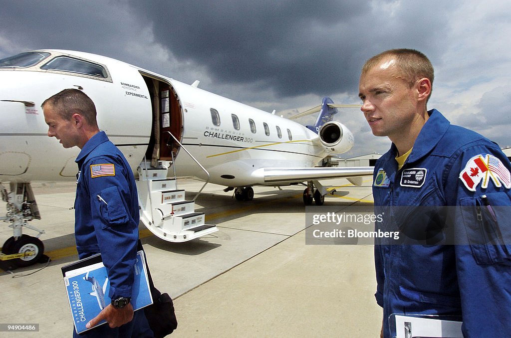 Test pilots Doug May, left, and Ed Grabman walk past a Chall