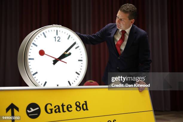 Daniel Gray of CA Global Partners poses with a clock during a preview of a forthcoming auction at Heathrow Airport on April 20, 2018 in London,...