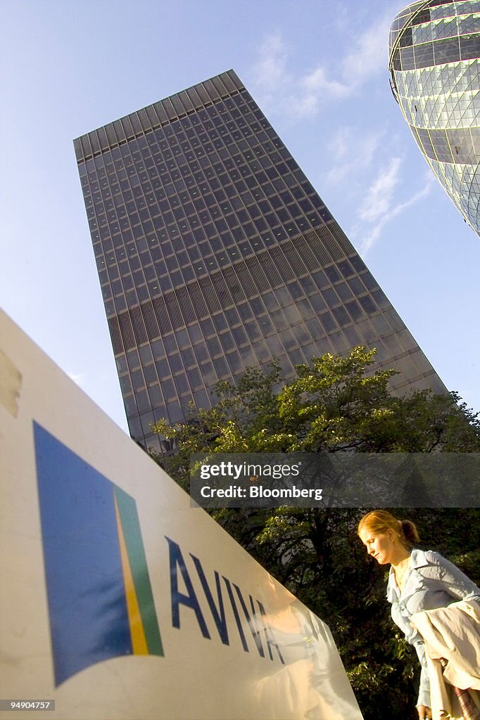 A pedestrian passes in front of the Aviva Plc office tower i