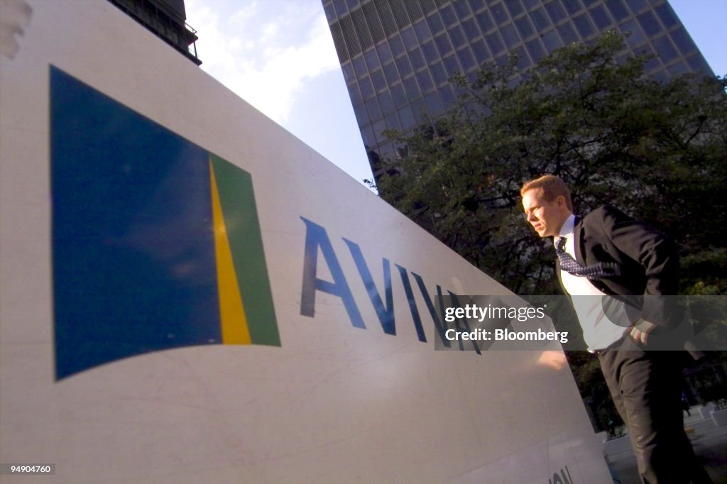 A pedestrian passes in front of the Aviva Plc office tower i
