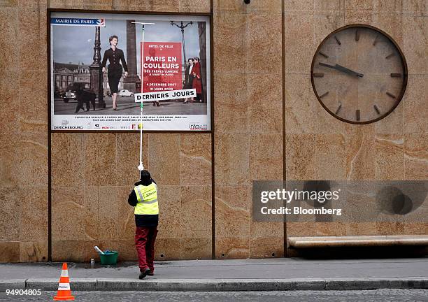 Said Caharasdine, a JC Decaux employee, washes an advertising panel in Paris, France, on Thursday, March 6, 2008. The company releases its yearly...