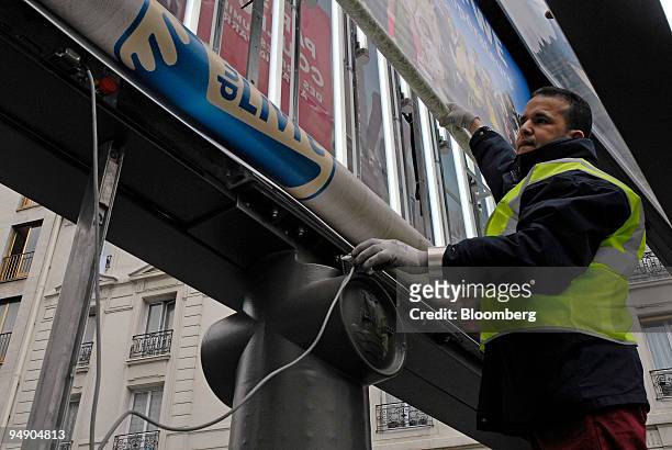 Said Caharasdine, a JC Decaux employee, changes an advertising panel in Paris, France, on Thursday, March 6, 2008. The company releases its yearly...