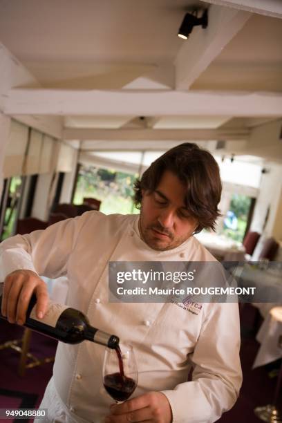 Alain LLORCA se servant du vin.