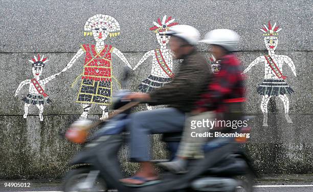 Residents on a scooter travel past a mosaic depicting the Amis tribe in Talampo, Hualien county, Taiwan, on Friday, Jan. 18, 2008. The Amis tribe,...