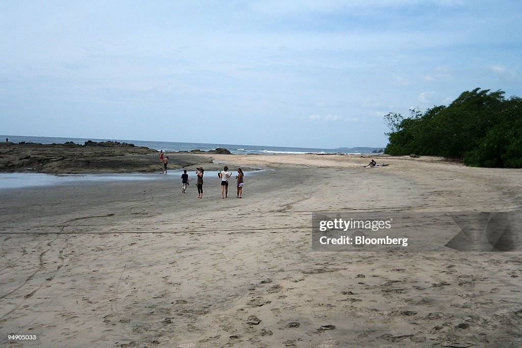 Beach-goers walk along the Pacific Ocean on Playa Pelada, No