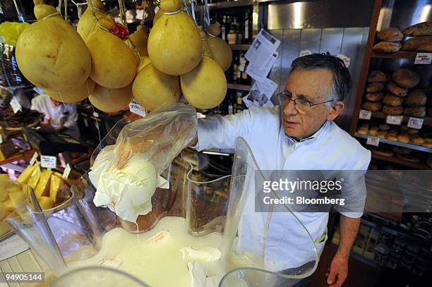 Emilio Volpetti picks out a buffalo milk mozzarella portion at his delicatessen in the Testaccio area of Rome, Italy, on Thursday, April 10, 2008....