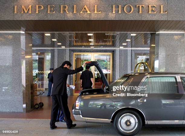 Bellhop checks the luggage in a limousine in front of the Imperial Hotel in Tokyo Wednesday, July 14, 2004. Colony Capital LLC, a Los Angeles-based...