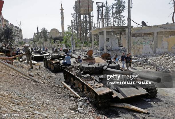 Destroyed tanks and armoured personnel carriers are pictured on a road in the Eastern Ghouta town of Douma on the outskirts of the capital Damascus...