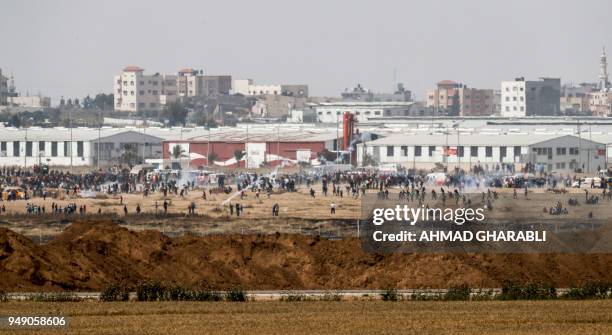 Picture taken on April 20, 2018 from the southern Israeli kibbutz of Nahal Oz across the border with the Gaza Strip shows Palestnian protesters...