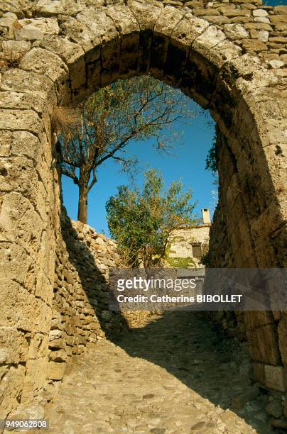 Minerve on its rocky outcrop, above the steep river valleys of the Cesse and the Brian, in the Minervois region. A fortified city gate, remnant of...