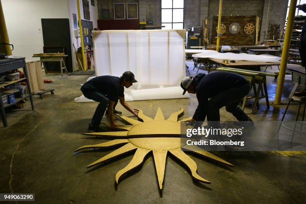 Workers prepare to package a wooden sun sculpture, commissioned for Starbucks Corp., at the Old Wood Co. Sustainable furniture manufacturing facility...