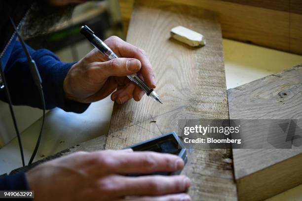 Worker marks wood at the Old Wood Co. Sustainable furniture manufacturing facility in Asheville, North Carolina, U.S., on Wednesday, April 11, 2018....