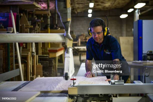 Worker uses a table saw to cut wood for a cabinet at the Old Wood Co. Sustainable furniture manufacturing facility in Asheville, North Carolina,...