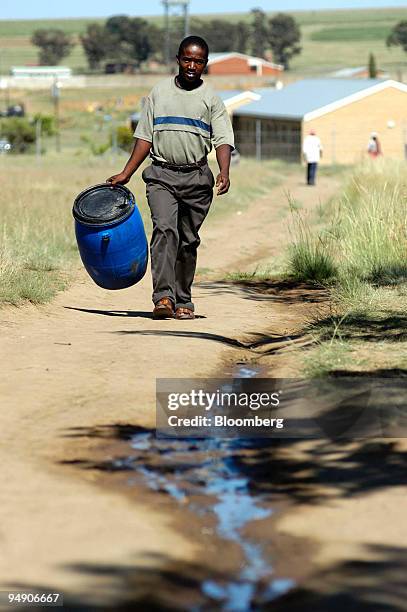 Man walks to collect water from an emergency supply in Leratswana township, Arlington, Eastern Free State, South Africa, Tuesday, February 3, 2004....