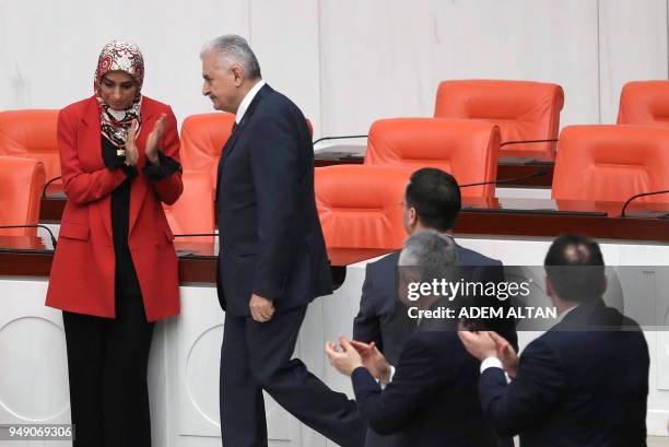 Members of Parliament applaud as Turkish Prime Minister Binali Yildirim arrives to speak during the debate motion on proposed early presidential and...