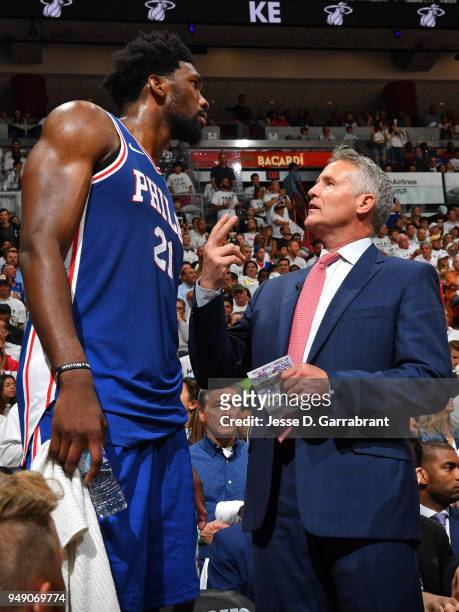 Joel Embiid of the Philadelphia 76ers talks with Brett Brown during the game against the Miami Heat in Game Three of Round One of the 2018 NBA...