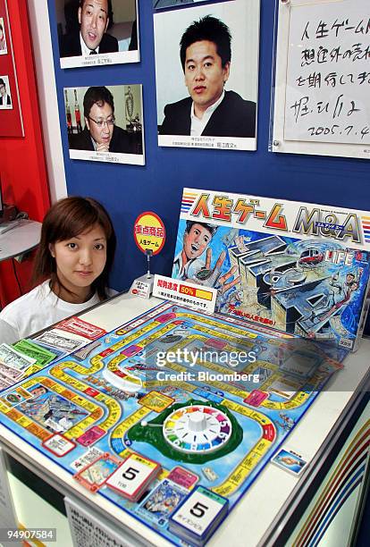 Takara Co. Employee shows off the company's 'The Game of Life M&A' at a toy show in Tokyo Thursday, July 21, 2005. Pictured above the game is a...