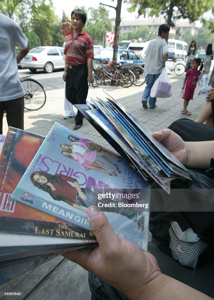 A vendor displays pirated DVDs of recently released films fo