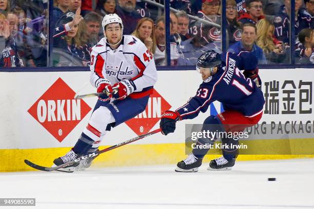 Tom Wilson of the Washington Capitals passes the puck past Cam Atkinson of the Columbus Blue Jackets in Game Three of the Eastern Conference First...