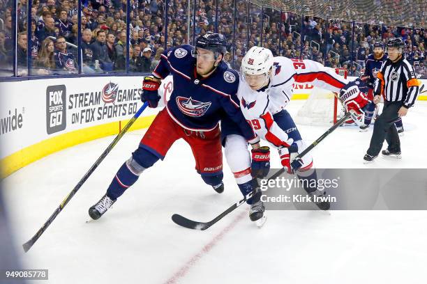 Pierre-Luc Dubois of the Columbus Blue Jackets and Alex Chiasson of the Washington Capitals chase after the puck in Game Three of the Eastern...