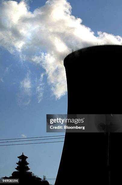 An old Chinese temple atop a nearby hill is dwarfed by a huge cooling tower at a power plant operated by Datang International Power Generation Co. In...