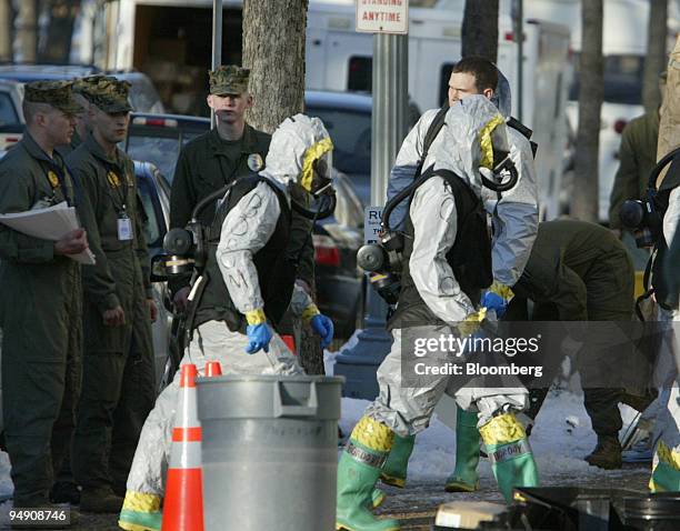 Technicians wearing protective decontamination suits work outside the Russell Senate Office Building in Washington D.C. On February 4, 2004. They are...
