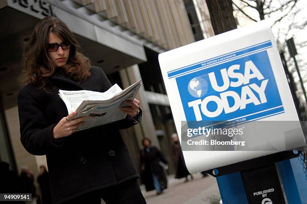 Woman glances over her just-purchased copy of Gannett Co.'s USA Today on Washington DC's K Street on Monday, February 2, 2004. Gannett Co., the...