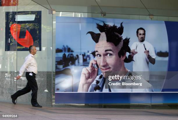 Man walks by advertisements for Telstra's mobile phone service at a Telstra Shop in Sydney, Australia Wednesday, June 16, 2004. Telstra Corp. May...