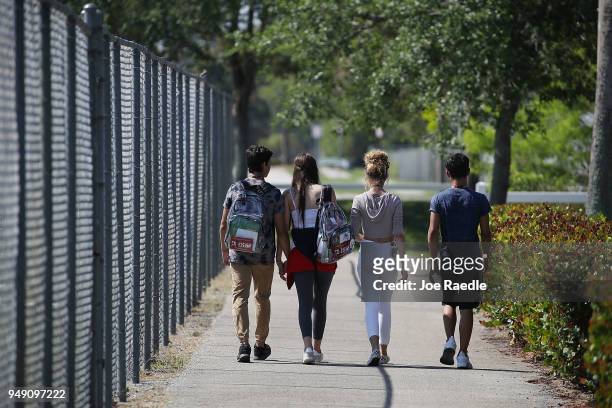 Students from Marjory Stoneman Douglas High School, where 17 classmates and teachers were killed during a mass shooting, leave school together for...