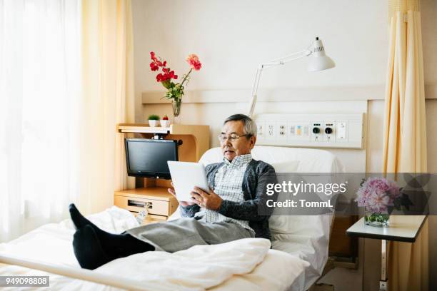 patient âgé pose dans son lit d’hôpital - lit dhôpital photos et images de collection