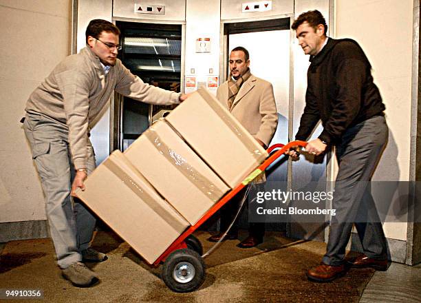 Members of the Guardia della Finanza, the police unit investigating financial fraud, remove boxes of documents from the Bank of America offices in...