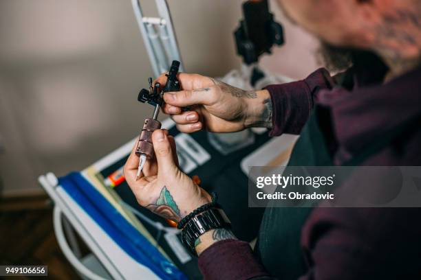 tatuering artist innehar tatuering pistol med fastsatt nål - surgical suture bildbanksfoton och bilder