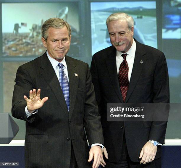 President George W. Bush, left, waves goodbye after outlining plans for space travel in the coming decades, January 14, 2004 at NASA headquarters in...