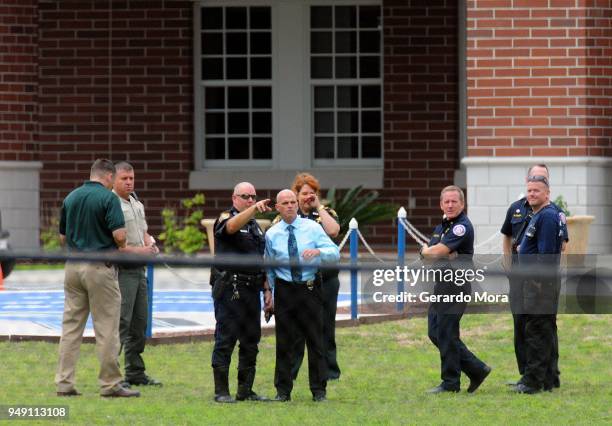 Police officers and local authorities stand in front of Forest High School after a school shooting on April 20, 2018 in Ocala, Florida. It was...