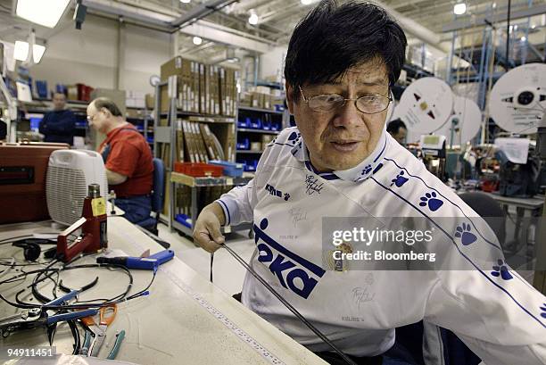 Lee Mercado measures and cuts wire leads in the preassemble area at the Danfoss Drives manufacturing plant in Rockford, Illinois January 6, 2004....