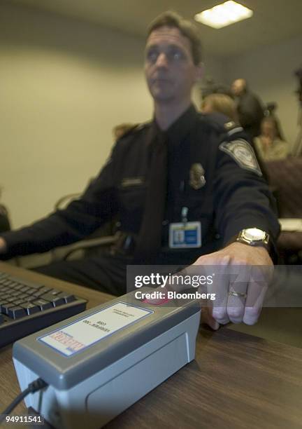 Customs and Border Protection officer Raymond Spiekerman demonstrates a fingerprint scanner that his agency will use to verify the identity of...