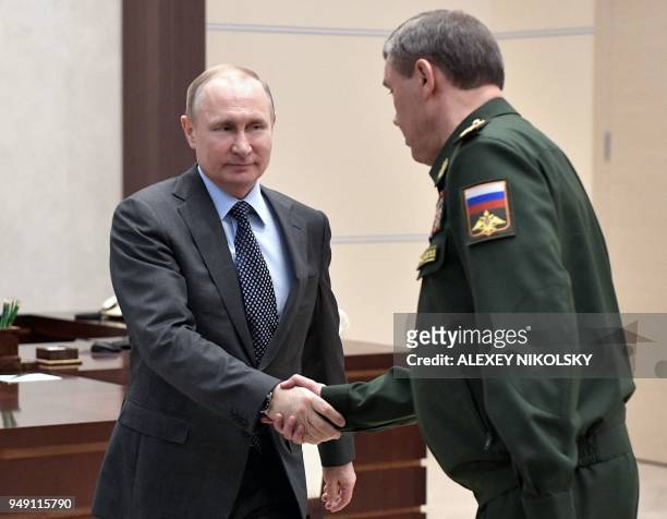 Russian President Vladimir Putin shakes hands with Chief of the General Staff of the Russian Armed Forces and First Deputy Defence Minister Valery...