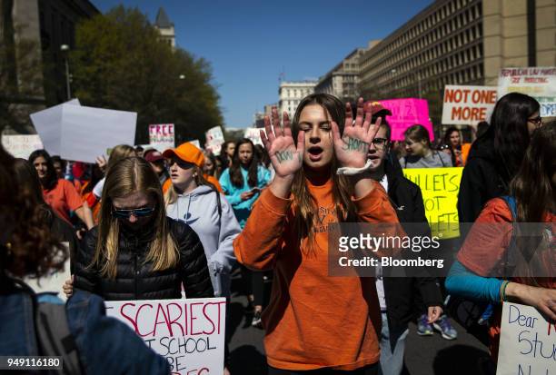 Demonstrator holds out her hands displaying the words "Don't Shoot" while marching from the White House to the U.S. Capitol during a school walkout...