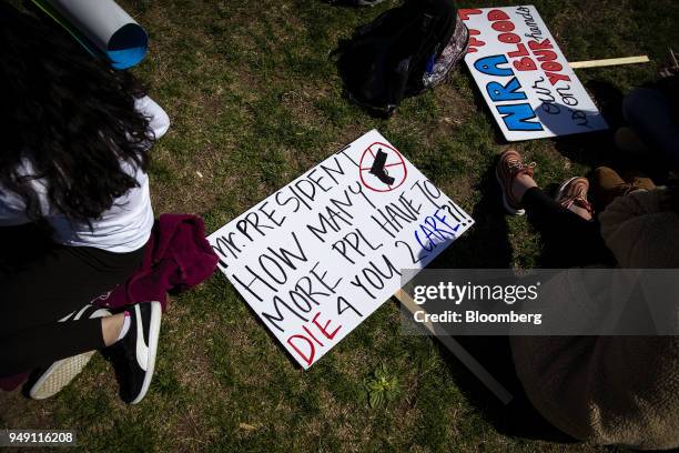 Sign that reads "Mr. President How Many More People Have To Die For You To Care?! " lays on the ground during a school walkout protesting the...