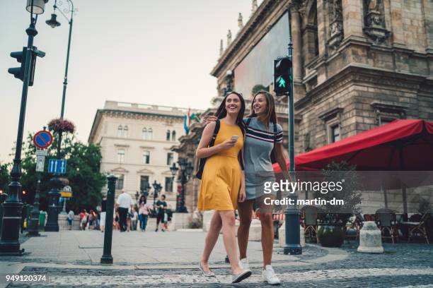 young women in budapest crossing the street at the pedestrian walkway - budapest stock pictures, royalty-free photos & images