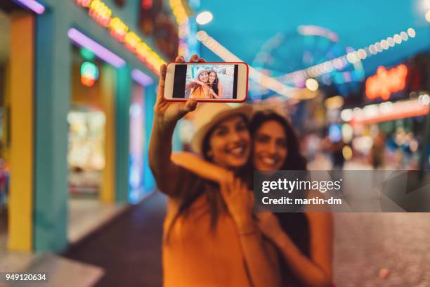 frauen im freizeitpark nehmen selfie - voip stock-fotos und bilder