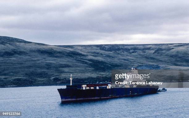 The Atlantic Conveyor in San Carlos Waters with one of HMS Fearless landing craft at the stern during the Falklands War, 1982. The ship was damaged...
