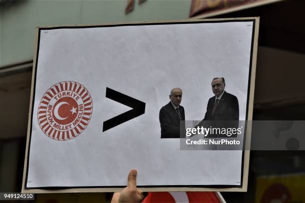 Man holds up a placard that depicts the Grand National Assembly of Turkey is bigger than MHP's Chairman Devlet Bahceli and Turkish President Recep...