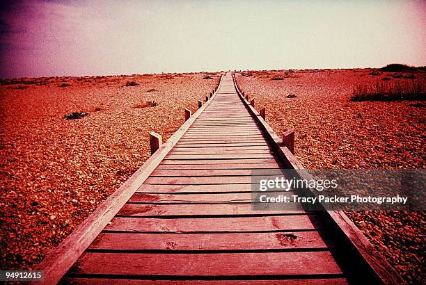 a boardwalk over shingle to the sea. - dungeness stock pictures, royalty-free photos & images