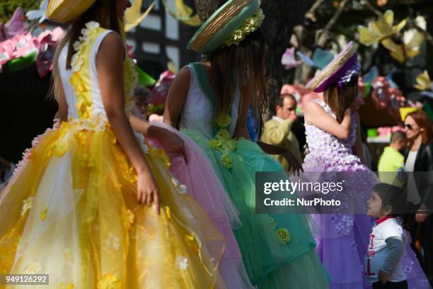 Young girl looks at the Dream Flowers by Isabel Borges - hostesses wearing a hand made floral dresses and hats in the center of Funchal, the capital...