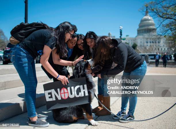 Students pet a dog near the US Capitol after rallying with several hundred fellow students to call for stricter gun laws in Washington, DC on April...