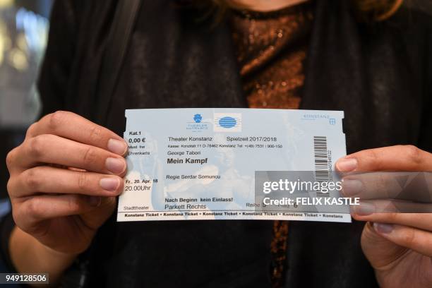 Picture taken on April 20, 2018 shows a woman holding a ticket to the play "Mein Kampf" written by George Tabori and staged by himself at the theatre...