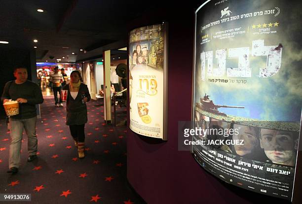Israelis walk past a poster for the movie �Lebanon� displayed at a cinema in Herzliya, north of Tel Aviv, on November 27, 2009. Israeli director...